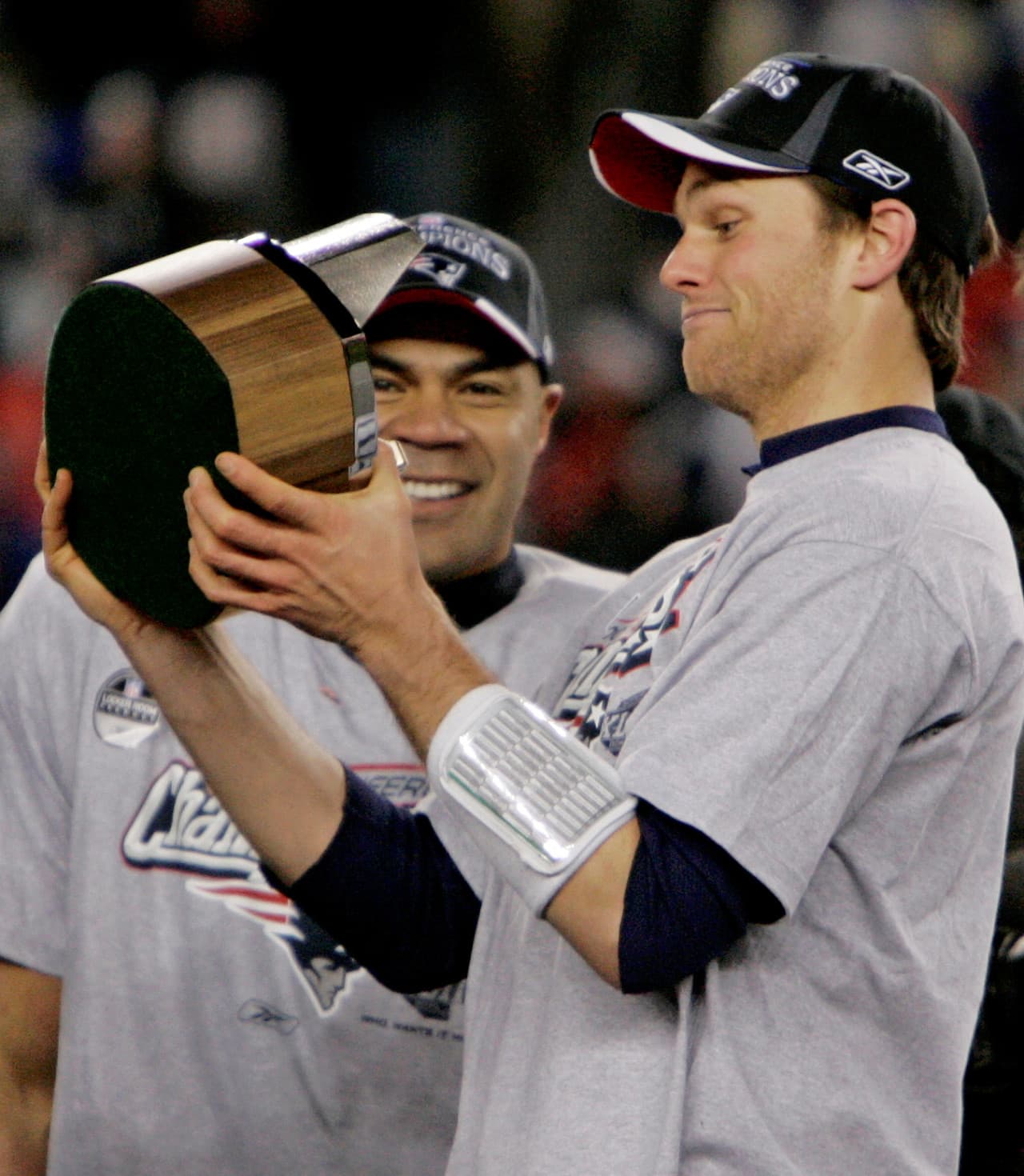 New England Patriots quarterback Tom Brady, right, holds the Lamar Hunt Trophy as Junior Seau looks on after defeating the San Diego Chargers 21-12 in the AFC Championship football game in 2008. (Winslow Townson/AP)