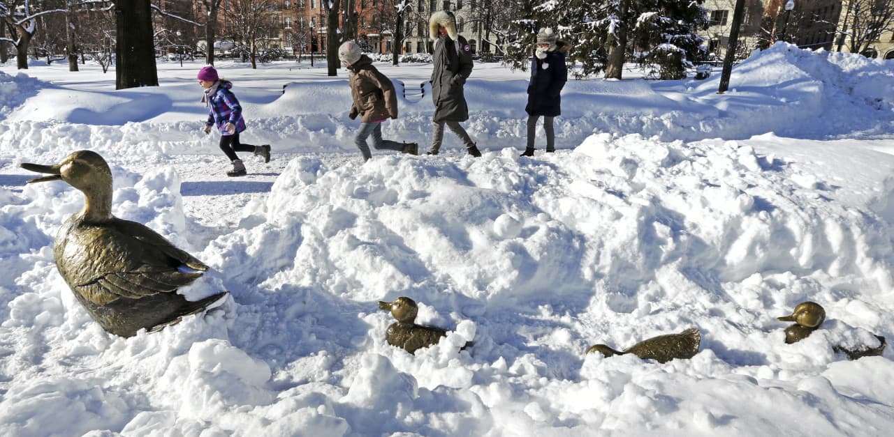 Children run through the Boston Public Garden, passing the nearly snow-covered "Make Way for Ducklings" statues, after the last major snowstorm. The city is bracing for another couple feet of snow. (Charles Krupa/AP)