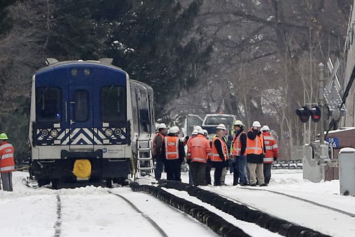 Officials examine the railroad crossing and the back of a Metro-North Railroad commuter train, Wednesday, Feb. 4, 2015 in Valhalla, N.Y. Five train passengers and the SUV’s driver were killed in Tuesday evening’s crash in Valhalla, about 20 miles north of New York City. (AP)