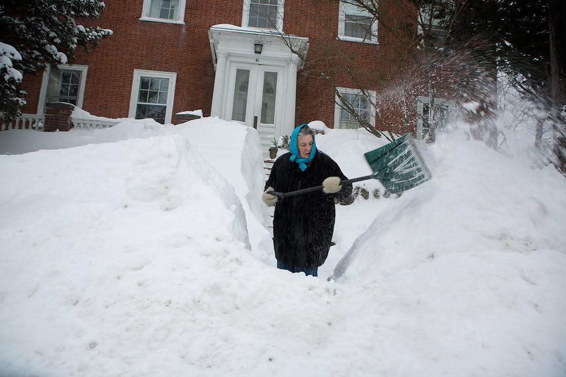 Margette Leanna shovels out her walkway early Monday morning in Newburyport. (Jesse Costa/WBUR)