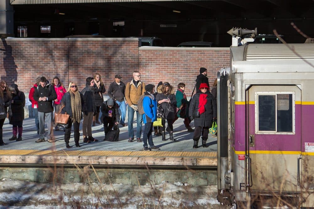 Commuters wait on the platform in Salem as an MBTA commuter rail train arrives in early March. (Jesse Costa/WBUR)