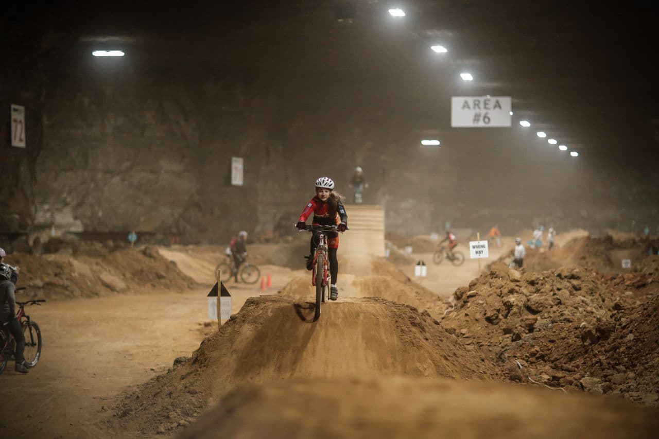 A young mountain biker tests out her skills on a series of dirt jumps.