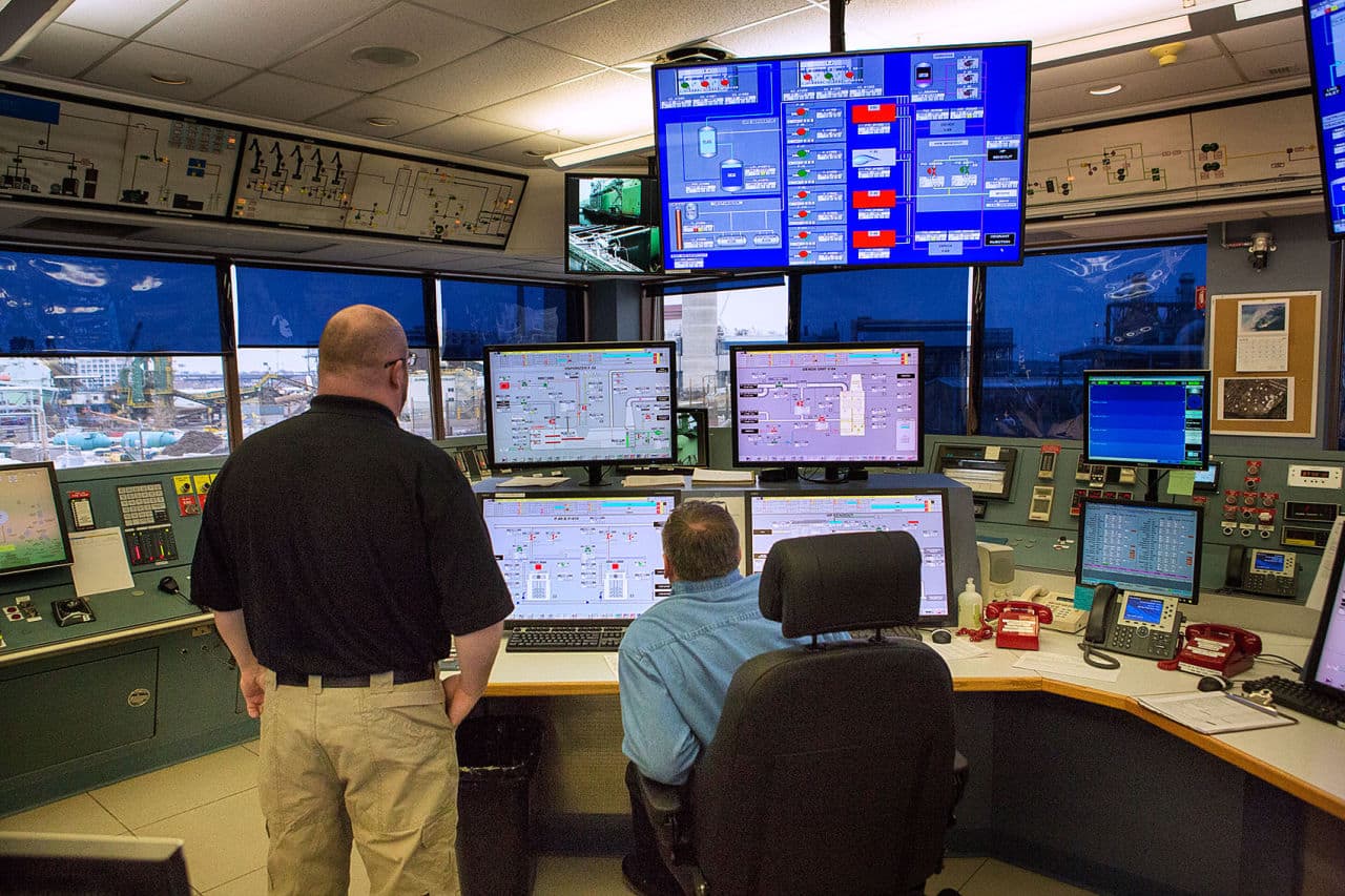 Ken Sparks, left, and Joe Stanford monitor operations from the control room at the Everett Distrigas terminal. Liquid natural gas is taken from tankers and then stored. The liquid is then distributed by truck or vaporized and distributed by pipeline. (Jesse Costa/WBUR)