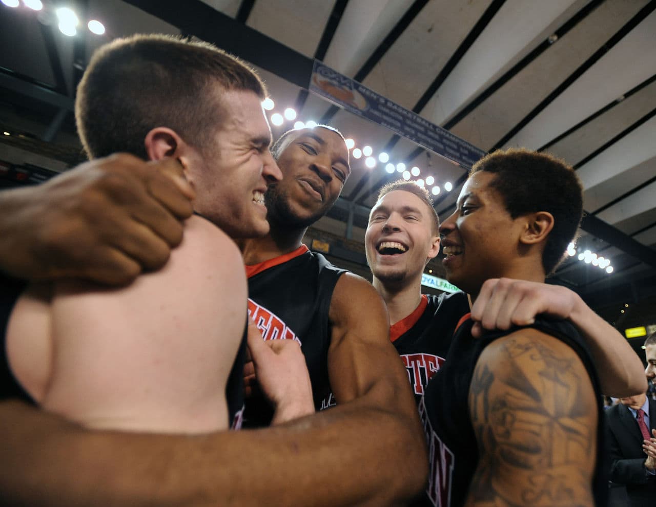 Northeastern celebrates after topping William & Mary Monday night in the CAA tournament championship game. The Huskies are in the Big Dance for the first time since 1991. (Caleb Donnelly/AP)