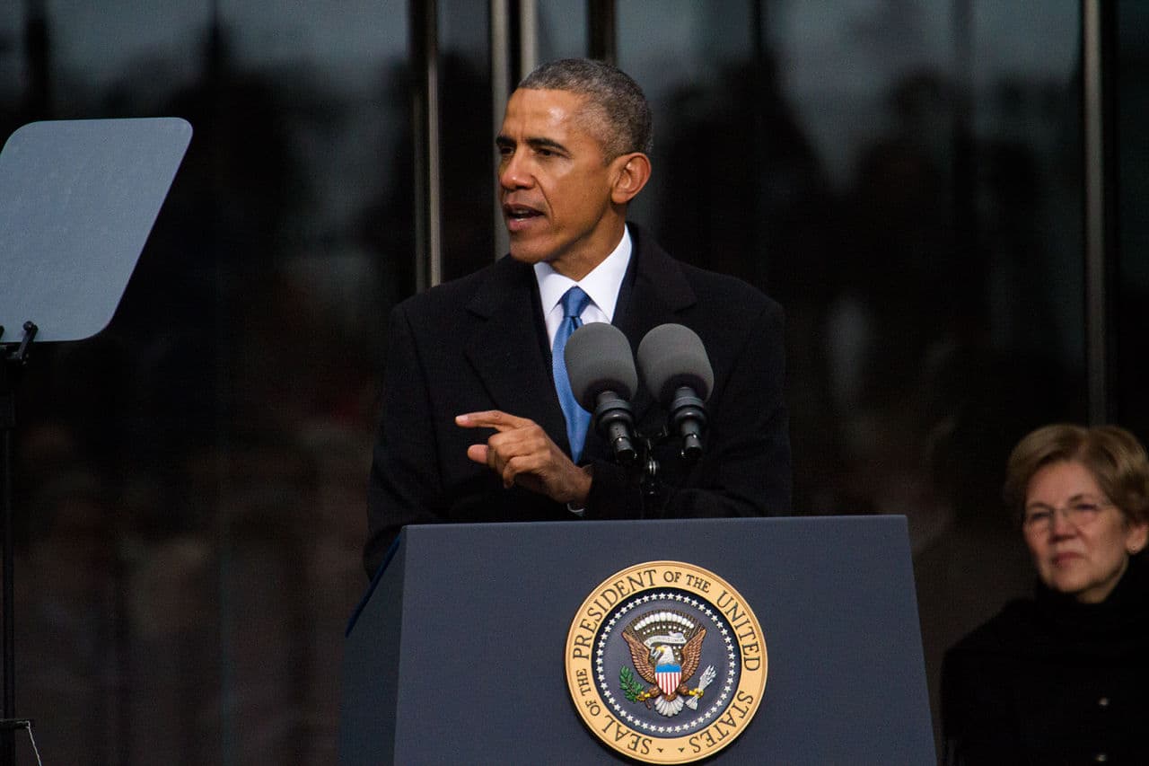 Surrounded by Kennedys and other politicians, like Sen. Elizabeth Warren, President Obama speaks at the dedication of the Edward M. Kennedy Institute for the United States Senate in Boston on Monday. (Jesse Costa/WBUR)