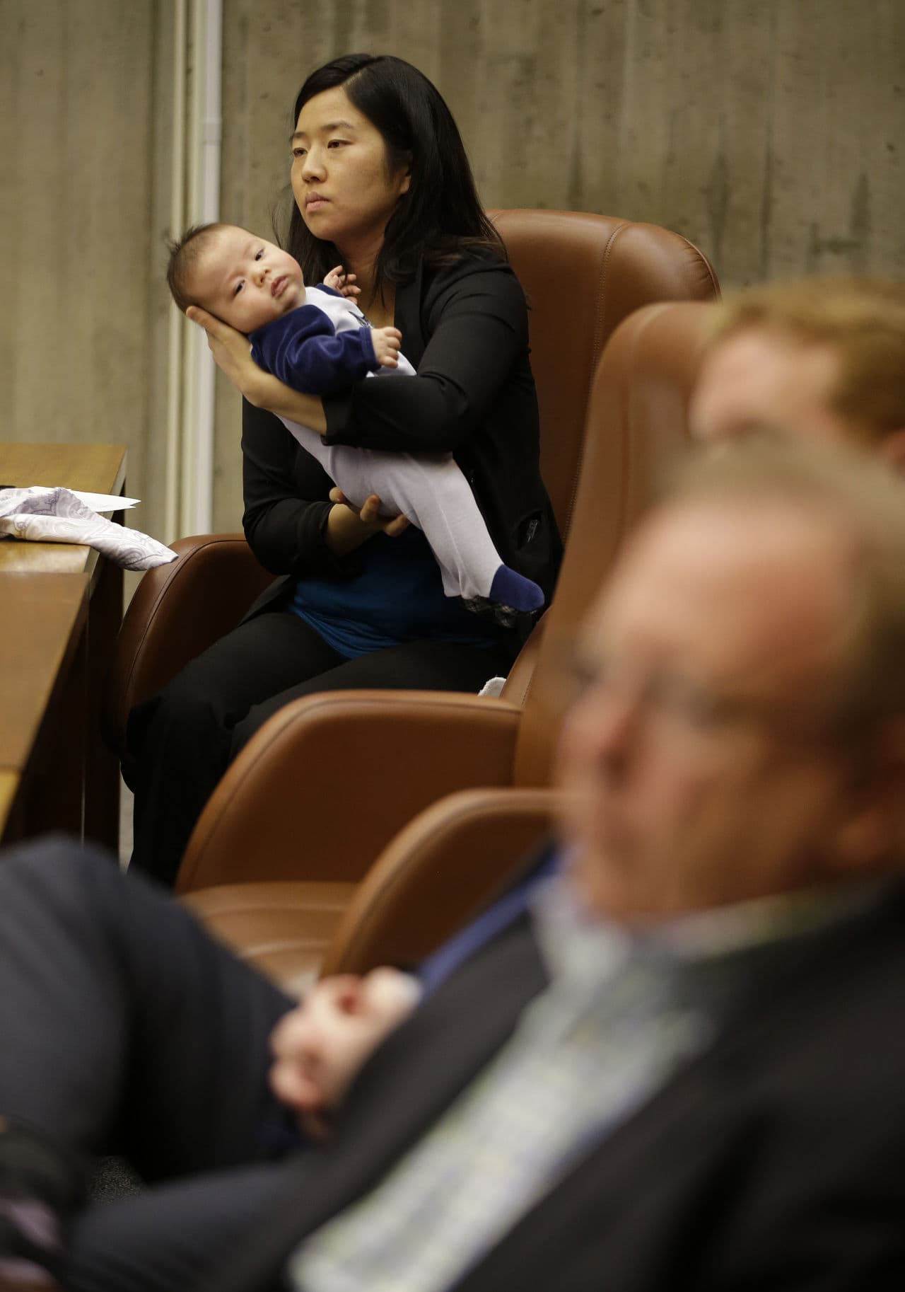Boston City Councilwoman Michelle Wu holds her eleven week-old son Blaise Pawarski as members of Boston 2024 answer questions during the first meeting of the Boston City Council on the city's bid to be awarded the 2024 Summer Olympics, Friday March 6, 2015, at City Hall in Boston. (AP)