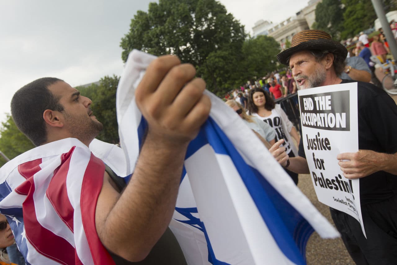 Two Demonstrators argue, one supporting Israel, left, and another supporting Palestine, right, in front of the White House in Washington,  Saturday, Aug. 9, 2014. (Pablo Martinez Monsivais/AP)