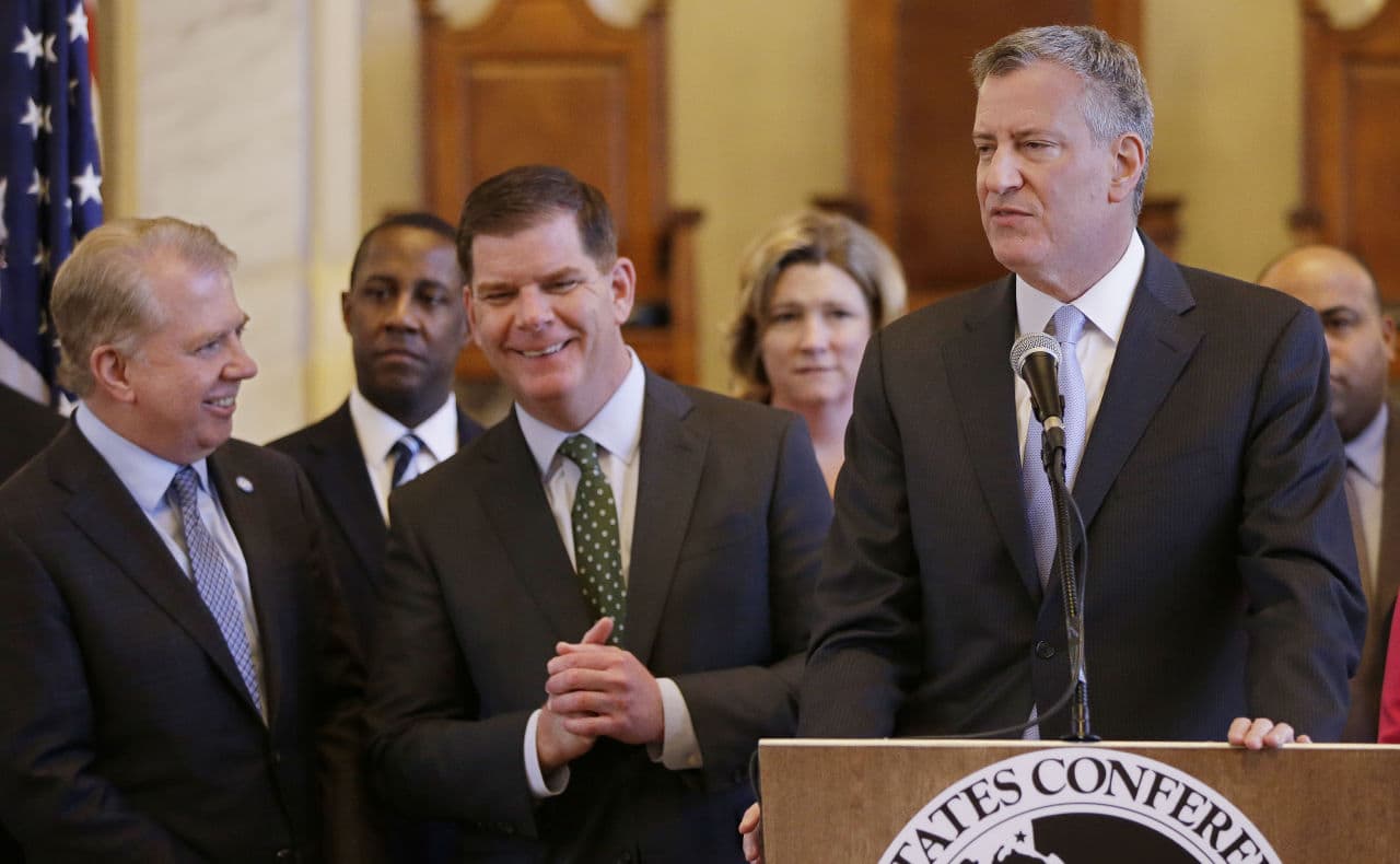 New York City Mayor Bill de Blasio, right, addresses members of the media as Boston Mayor Marty Walsh, center, and Seattle Mayor Ed Murray, left, talk during a media availability after a U.S. Conference of Mayor's Cities of Opportunity Task Force session at Boston's Faneuil Hall on Monday. (Stephan Savoia/AP)