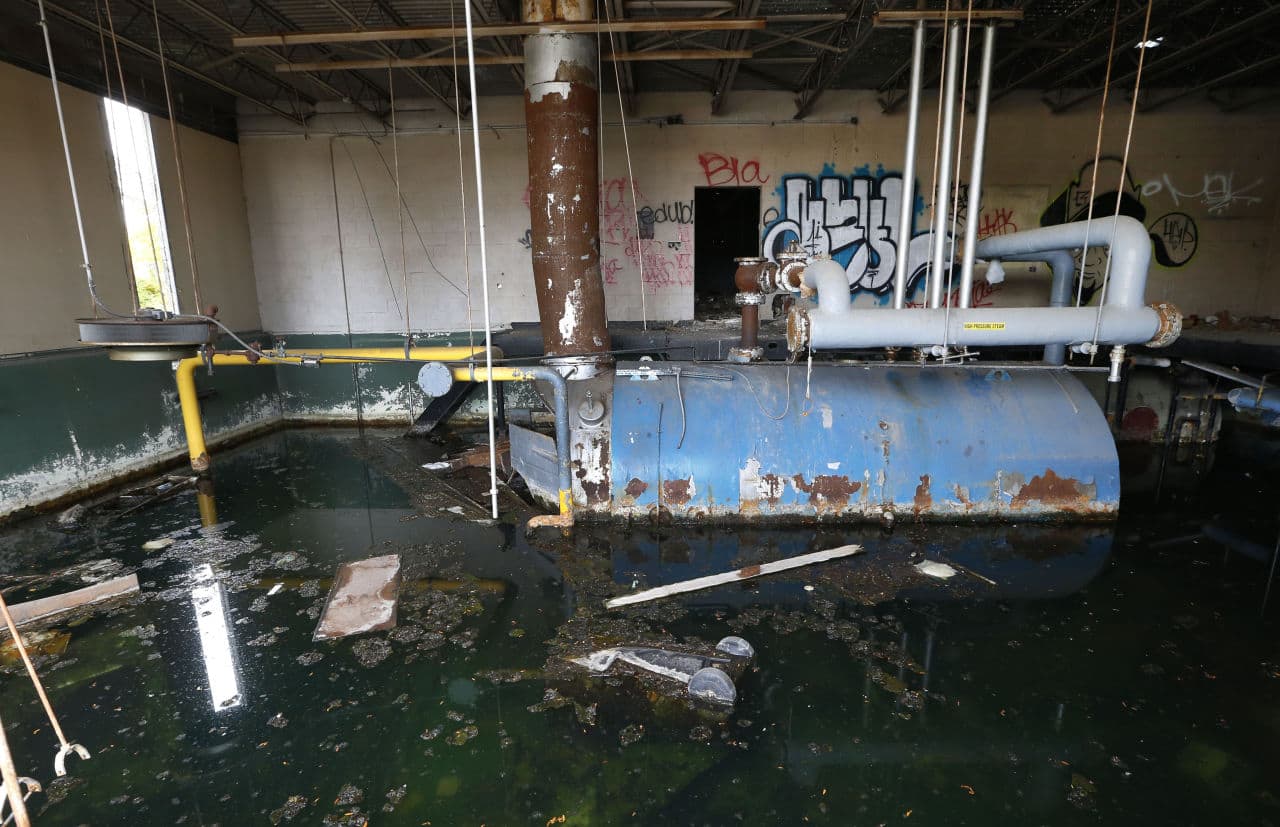 Water fills the boiler room at the former Frederick Douglass Academy in Detroit. The cost of such lost water is passed on in higher rates to water customers. (Paul Sancya/AP)