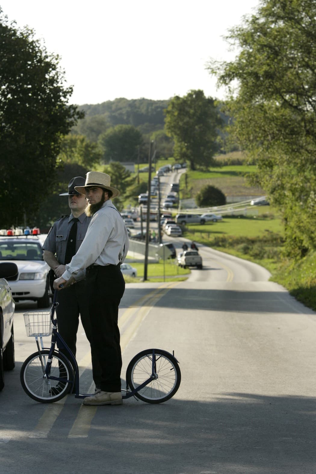 An Amish man talks to a police officer standing guard at the intersection leading to the site of the schoolhouse shooting in Nickel Mine, Pa. (Mary Altaffer/AP)