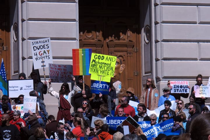 Some of the hundreds of people who gathered outside the Indiana Statehouse on Saturday, March 28, 2015, for a rally against legislation signed Thursday by Gov. Mike Pence stand on the Statehouse's south steps during the 2-hour-long rally. (AP)