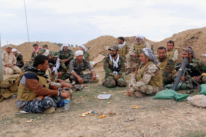 In this Wednesday, March 4, 2015 photo, Shiite militiamen rest behind a sand berm during fighting between the Iraqi army, supported by volunteers, and Islamic State militants outside Tikrit, 80 miles (130 kilometers) north of Baghdad, Iraq. (AP)