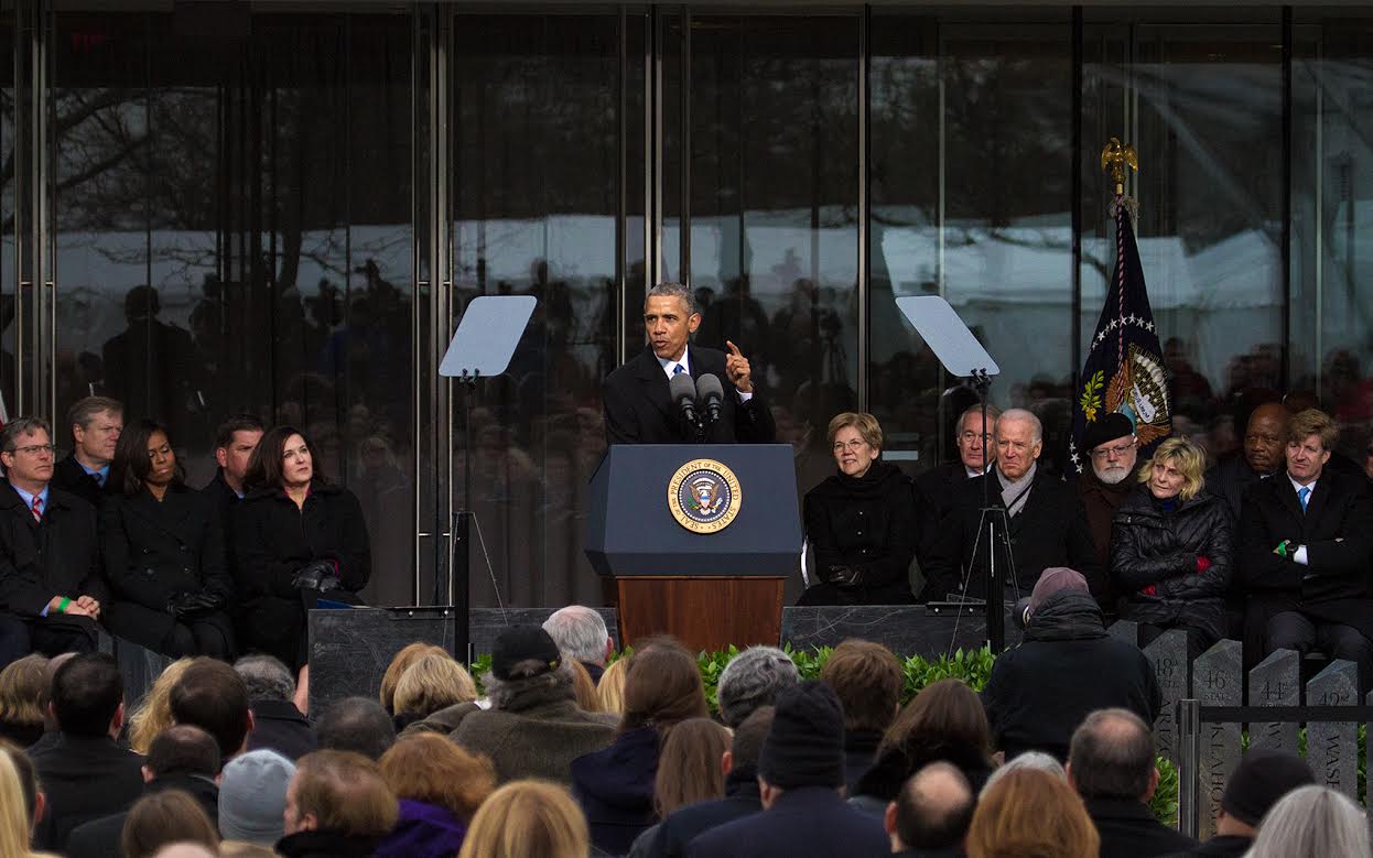 Surrounded by Kennedys and other politicians, President Obama speaks at the dedication of the Edward M. Kennedy Institute for the United States Senate in Boston. (Jesse Costa/WBUR)