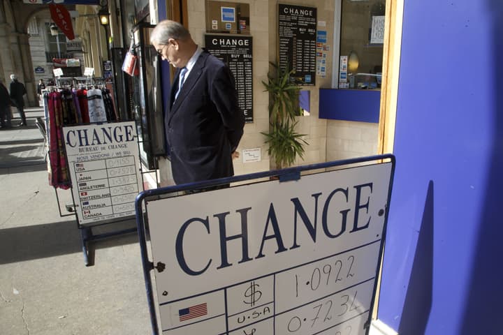A man looks at an exchange rate board in Paris, Friday, March 6, 2015. The euro could soon be doing something it's only done a couple of times in its 16-year existence, trading 1-to-1 with the dollar.  (A)