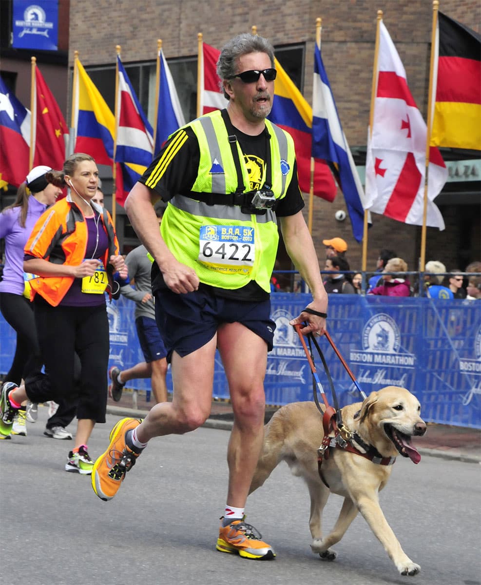 The late Quinn joyously approaches the finish line guiding Randy Pierce in the Boston Athletic Association’s 5k in 2013. (Courtesy 2020visionquest.org)