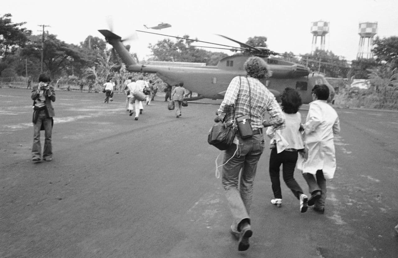 Americans and Vietnamese run for a U.S. Marine helicopter in Saigon during the evacuation of the city, April 29, 1975. (AP)
