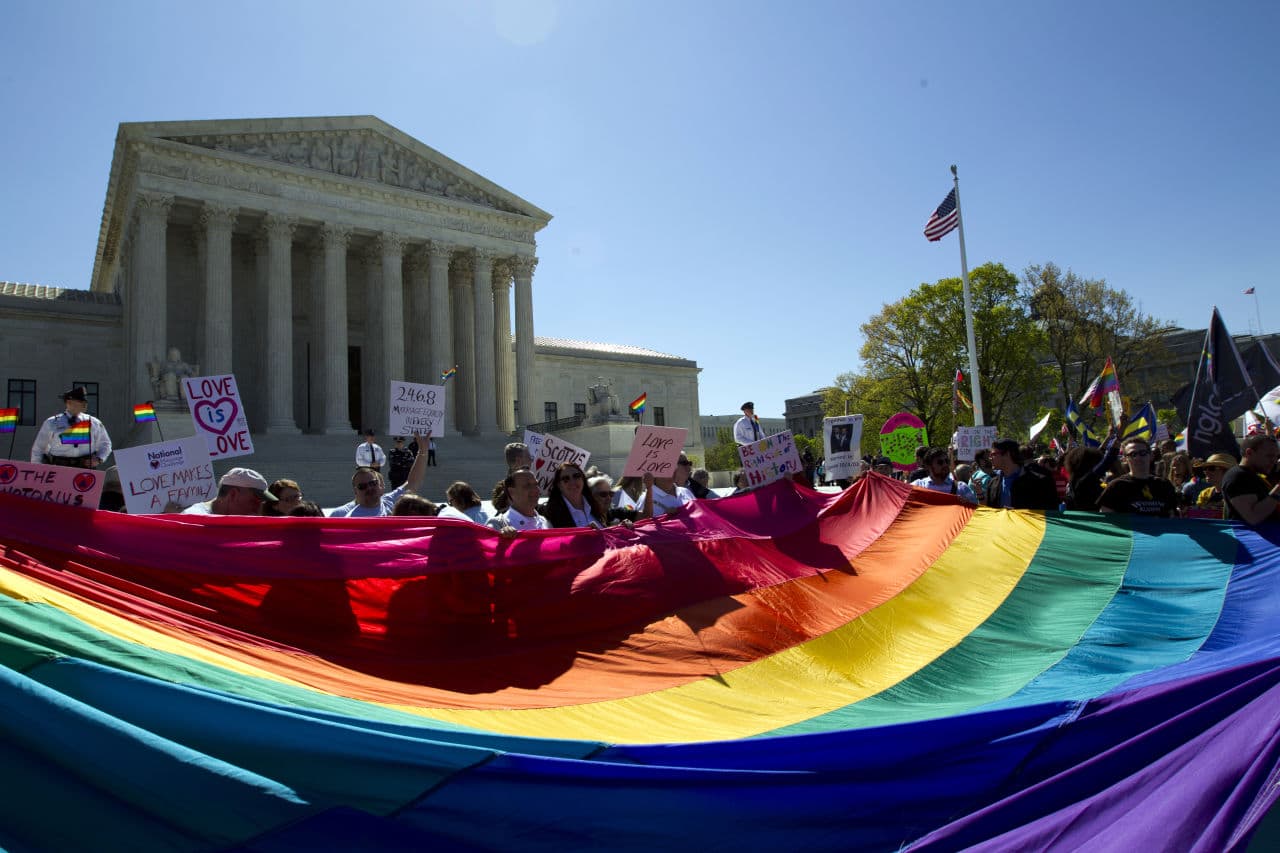 Demonstrators stand in front of a rainbow flag of the Supreme Court in Washington on Tuesday. The Supreme Court heard historic arguments in cases that could make same-sex marriage the law of the land. (Jose Luis Magana/AP)