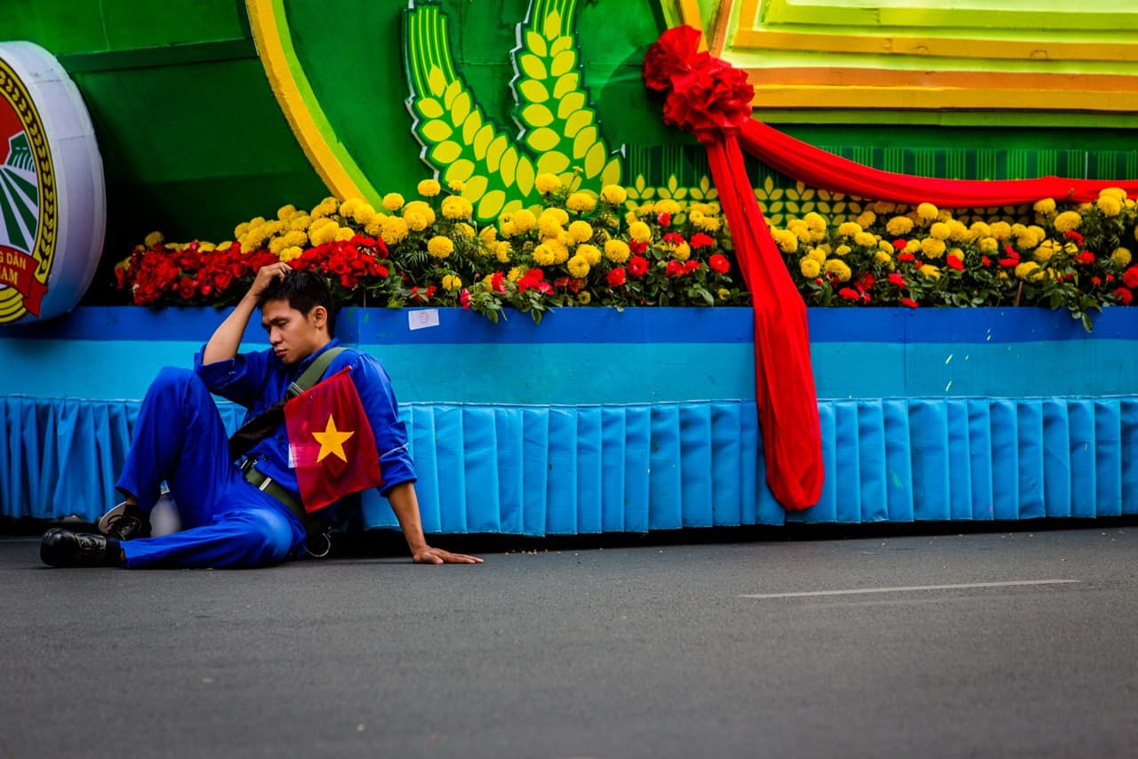 A man has a rest as he waits for the parade to proceed. (Quinn Ryan Mattingly for WBUR)