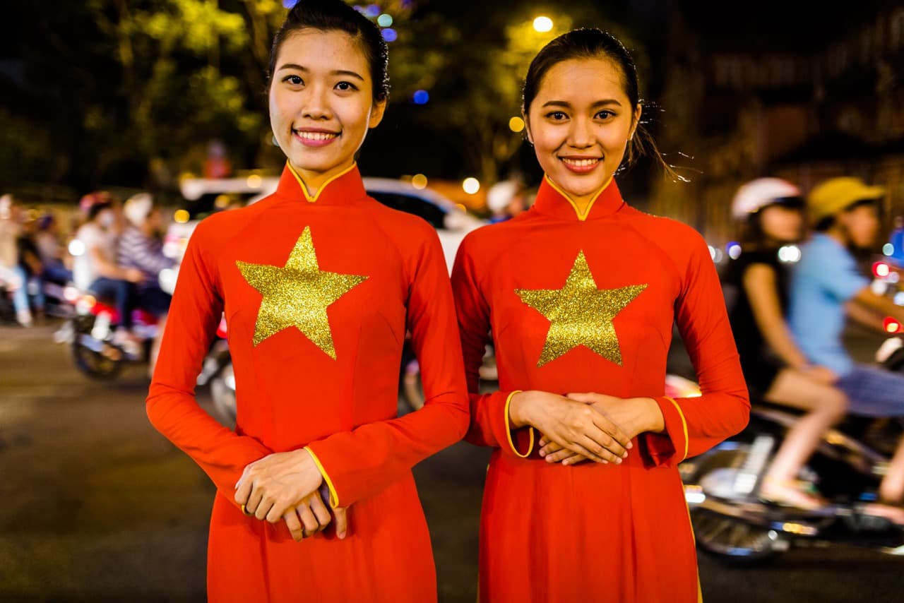 Vietnamese girls in a custom made yet traditional dress called an áo dài pose for a portrait hours before the parade in Ho Chi Minh City. (Quinn Ryan Mattingly for WBUR)