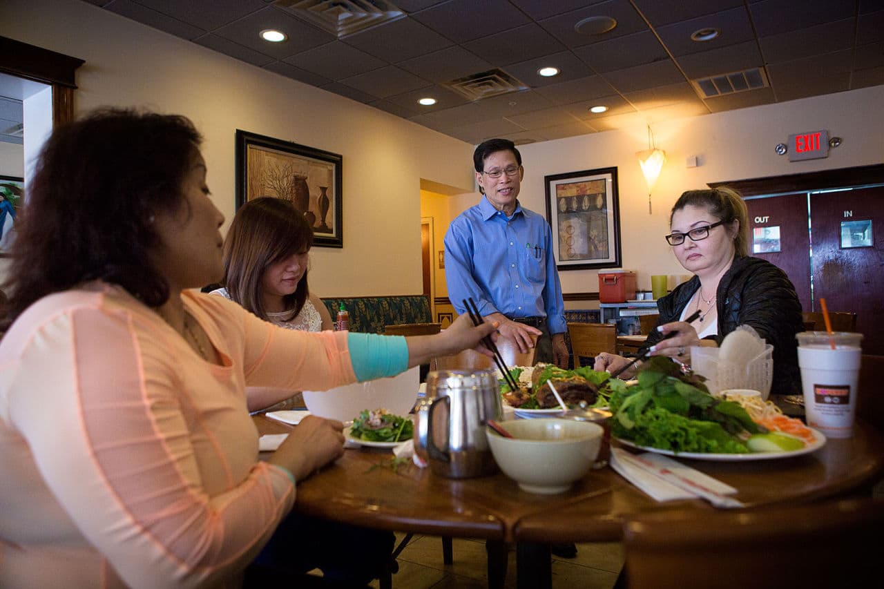 Duyan Le checks in on some customers at his restaurant Pho Le in Dorchester. After escaping Vietnam in 1986, he eventually settled in Boston and opened his first restaurant in 1991. (Jesse Costa/WBUR)