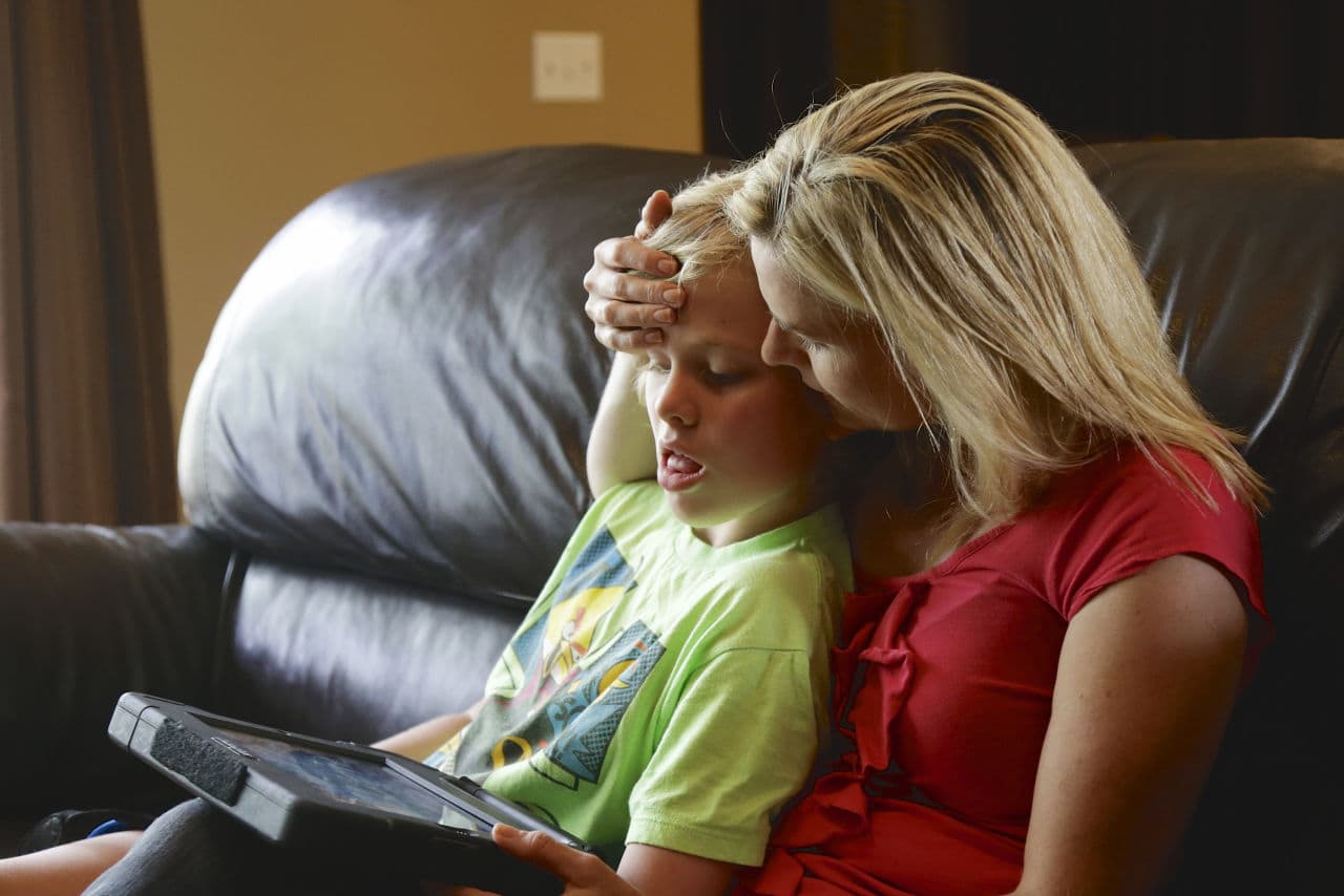In this May 23, 2014 photo, Colleen Jankovich works with her 11-year-old autistic son, Matthew, who is non-verbal and requires 24/7 care, in Omaha,  (AP)