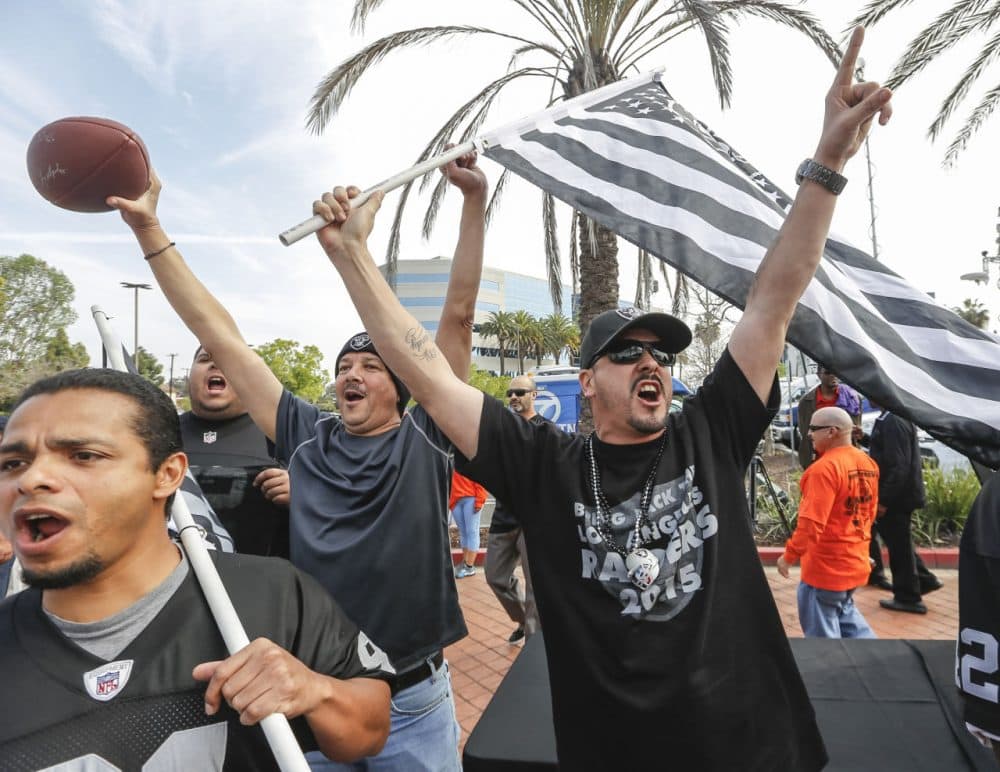 Raiders fan Sergio Gutierrez, right, joins football fans celebrating a proposed NFL football stadium by the owners of the San Diego Chargers and Oakland Raiders, during a news conference in Carson, Calif. (Damian Dovarganes/AP)
