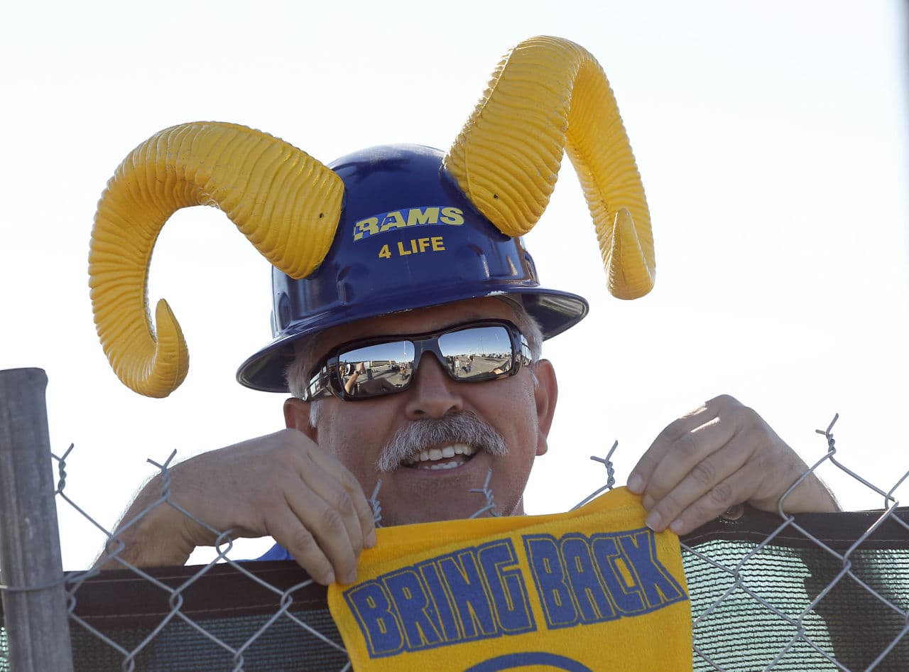 Rams fan Joe Ramirez stands behind a fence as officials with the Hollywood Park Land Company unveil a proposal for a new NFL stadium at Hollywood Park in Inglewood, Calif. (Nick Ut/AP)