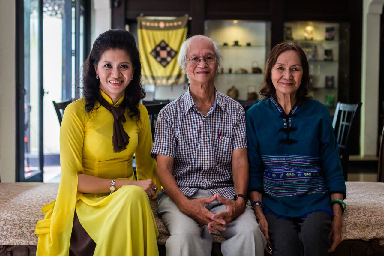 Nguyen Huu Thai, center, his daughter Nguyen Thien Nga, left, and wife Tran Tuyet Hoa pose at their family hotel in Ho Chi Minh City. (Quinn Ryan Mattingly for WBUR)