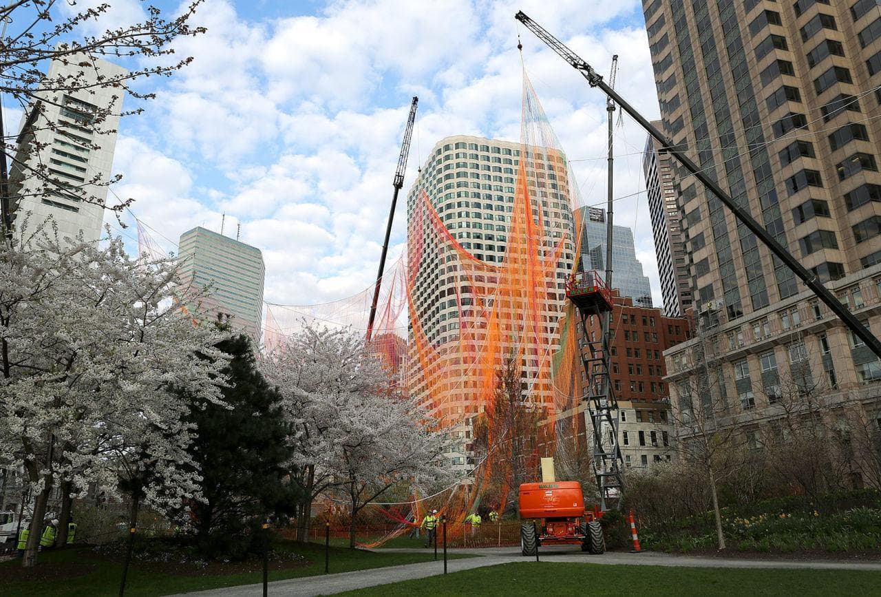 Early on Sunday morning construction cranes start raising Janet Echelman's aerial sculpture from The Greenway. (Robin Lubbock/WBUR)