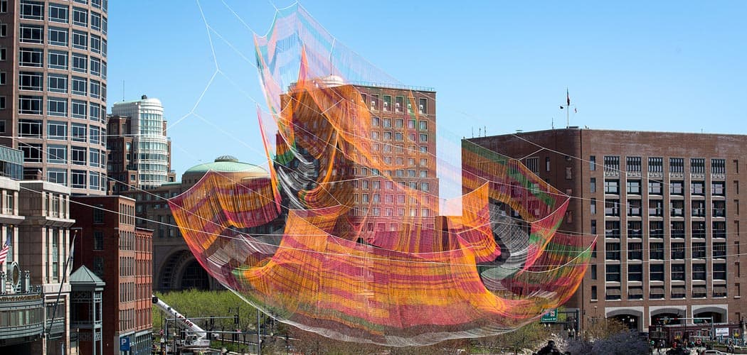 Janet Echelman's 2,000-pound fiber net sculpture  is suspended between three skyscrapers and looks like it's floating high above the Rose Kennedy Greenway. (Robin Lubbock/WBUR)