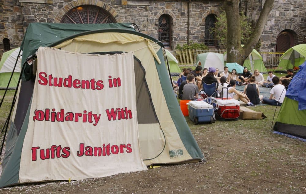 On Tuesday, Tufts University students hold a meeting in a campsite next to the school's administration building, where students have been protesting the university's plans to cut janitorial jobs. (Stephan Savoia/AP)