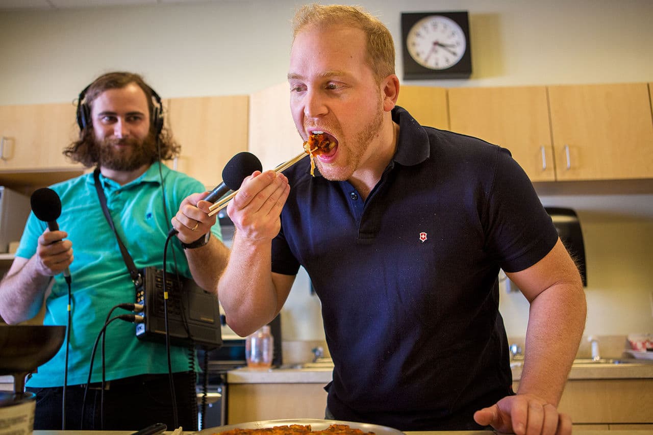 Here &amp; Now host Jeremy Hobson gives the kimchi pancake a taste. (Jesse Costa/WBUR)