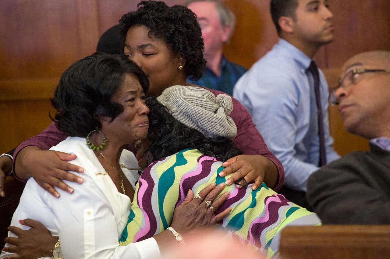 Mary Ellis, in white, is hugged after a judge granted her son, Sean Ellis, bail at his hearing Tuesday. (Jesse Costa/WBUR)