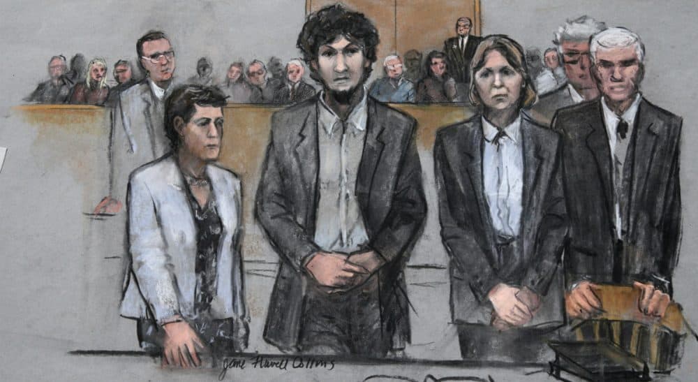 In this courtroom sketch, Boston Marathon bomber Dzhokhar Tsarnaev, center, stands with his defense attorneys as a death by lethal injection sentence is read at the Moakley Federal court house in the penalty phase of his trial in Boston, Friday, May 15, 2015. The federal jury ruled that the 21-year-old Tsarnaev should be sentenced to death for his role in the deadly 2013 attack. (Jane Flavell Collins/AP)
