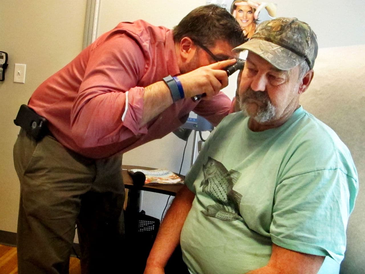 Dr. Jeff Gold and his patient Steve Bird, who is being examined for an earache (Martha Bebinger/WBUR)