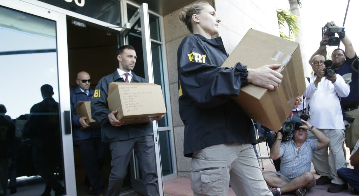 Federal agents load a van with boxes of evidence taken from the headquarters of the Confederation of North, Central America and Caribbean Association Football (CONCACAF,) Wednesday, May 27, 2015, in Miami Beach, Fla. Swiss prosecutors opened criminal proceedings into FIFA's awarding of the 2018 and 2022 World Cups, only hours after seven soccer officials were arrested Wednesday pending extradition to the U.S. in a separate probe of "rampant, systemic, and deep-rooted" corruption. (Wilfredo Lee/AP)
