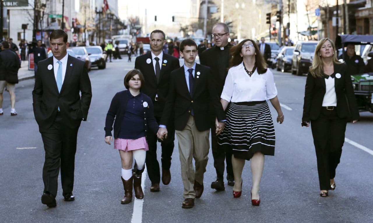 The family of Martin Richard, the youngest bombing victim, walks down Boylston Street with Boston Mayor Marty Walsh after a ceremony on Boylston Street, April 15, 2015. (Charles Krupa/AP)