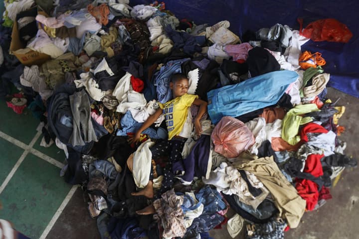 An ethnic Rohingya boy sleeps on a pile of used clothing donated by local residents at a sports stadium turned into temporary shelter for migrants whose boats washed ashore on Sumatra island on Sunday, in Lhoksukon, Aceh province, Indonesia, Wednesday, May 13, 2015.  (AP)