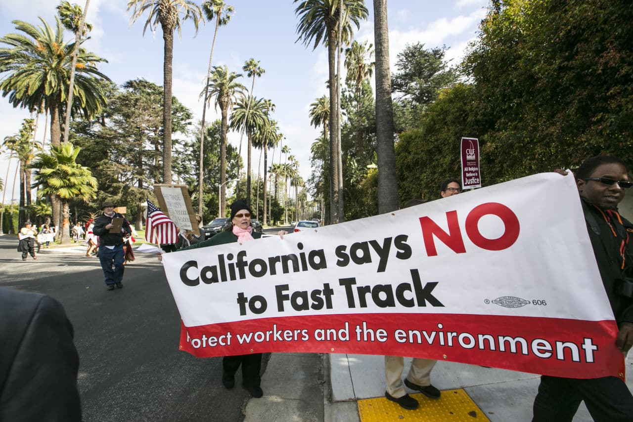 Los Angeles community members take to the streets of Beverly Hills to demand that Hillary Rodham Clinton oppose the Trans-Pacific Partnership (TPP) and Trade Promotion Authority (TPA) known as “The Fast Track,” in Beverly Hills, Calif., Thursday, May 7, 2015. (AP)
