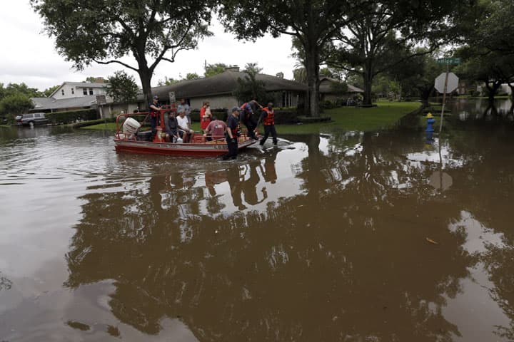 Residents are evacuated by members of the Houston Fire Department from floodwaters surrounding their homes in Houston, Tuesday, May 26, 2015. Heavy rain overnight caused flooding and closure of sections of highways in the Houston area. (AP)