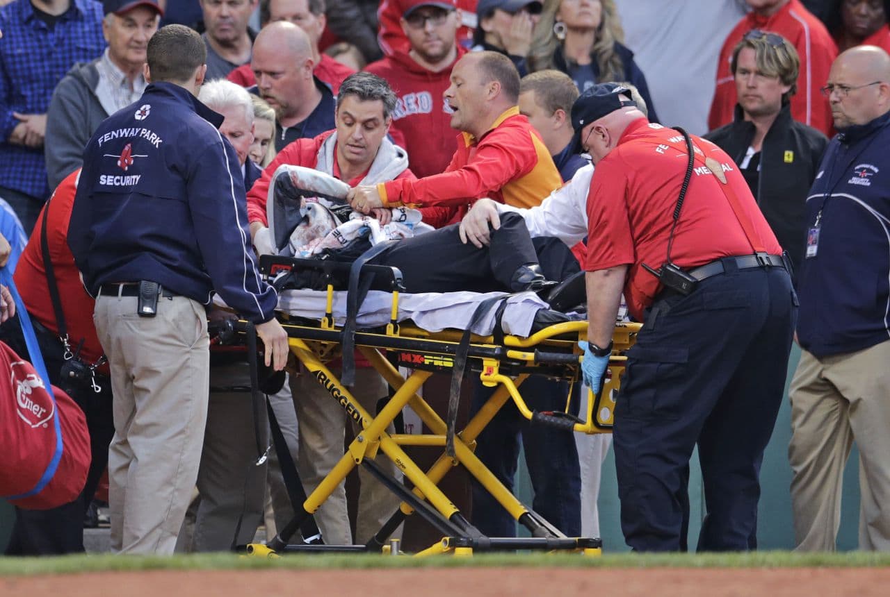 Tonya Carpenter, who was accidentally hit in the head with a broken bat by Oakland Athletics' Brett Lawrie, is helped from the stands during a game against the Red Sox at Fenway Friday. (Charles Krupa/AP)