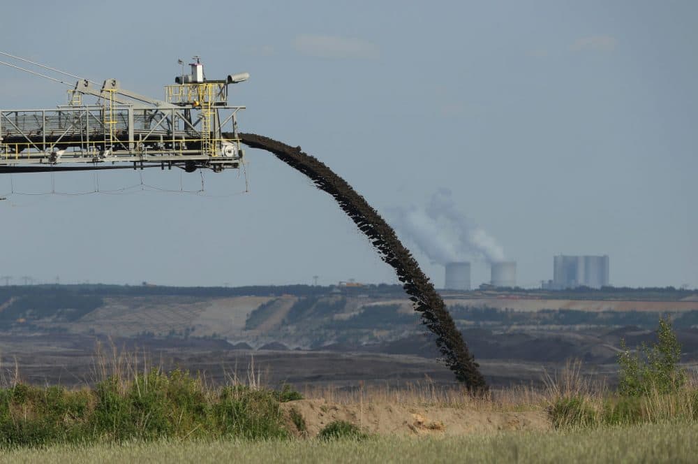 A conveyor bridge deposits soil removed from one end of the Welzow Sued open-pit lignite coal mine to allow excavators to reach the coal underneath as the Schwarze Pumpe coal-fired power plant stands behind on May 28, 2015 near Welzow, Germany. (Sean Gallup/Getty Images)