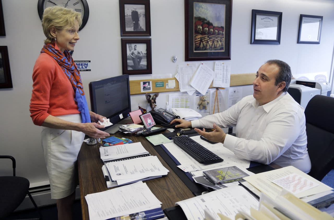 Police Chief Leonard Campanello confers with Joan Whitney, director of the Healthy Gloucester Collaborative, at his office in Gloucester earlier this month. His department promises to help find treatment for those suffering from opioid addiction who turn their drugs into the station. (Elise Amendola/AP)