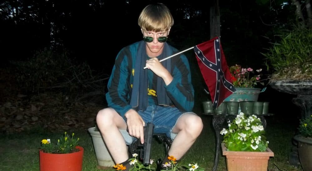 This undated image that appeared on Lastrhodesian.com, a website being investigated by the FBI in connection with Charleston, S.C., shooting suspect Dylann Roof, shows Roof posing for a photo while holding a Confederate flag. (Lastrhodesian.com via AP)