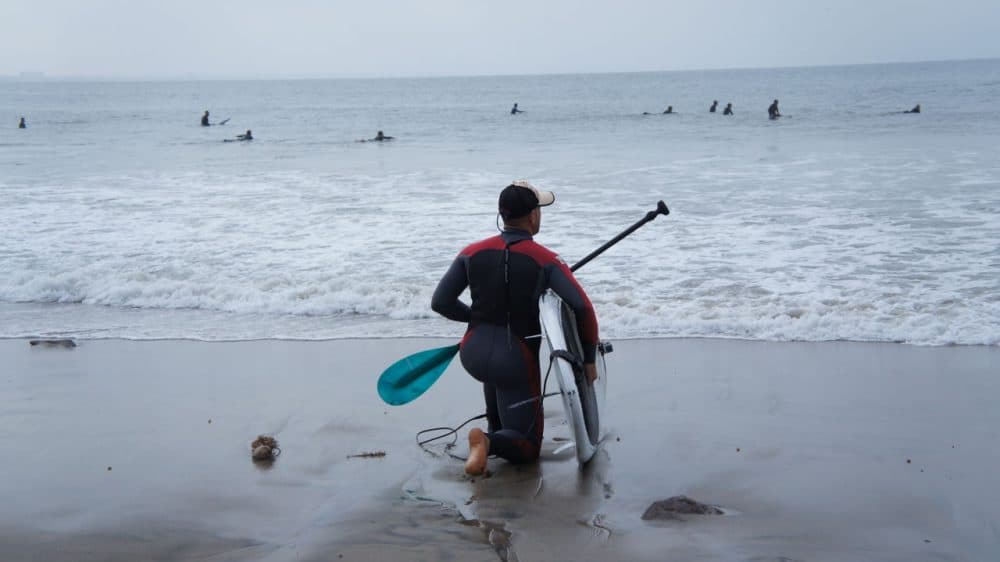 A paddle boarder surveys waves in Malibu before going into the water. (Saul Gonzalez/Only A Game)