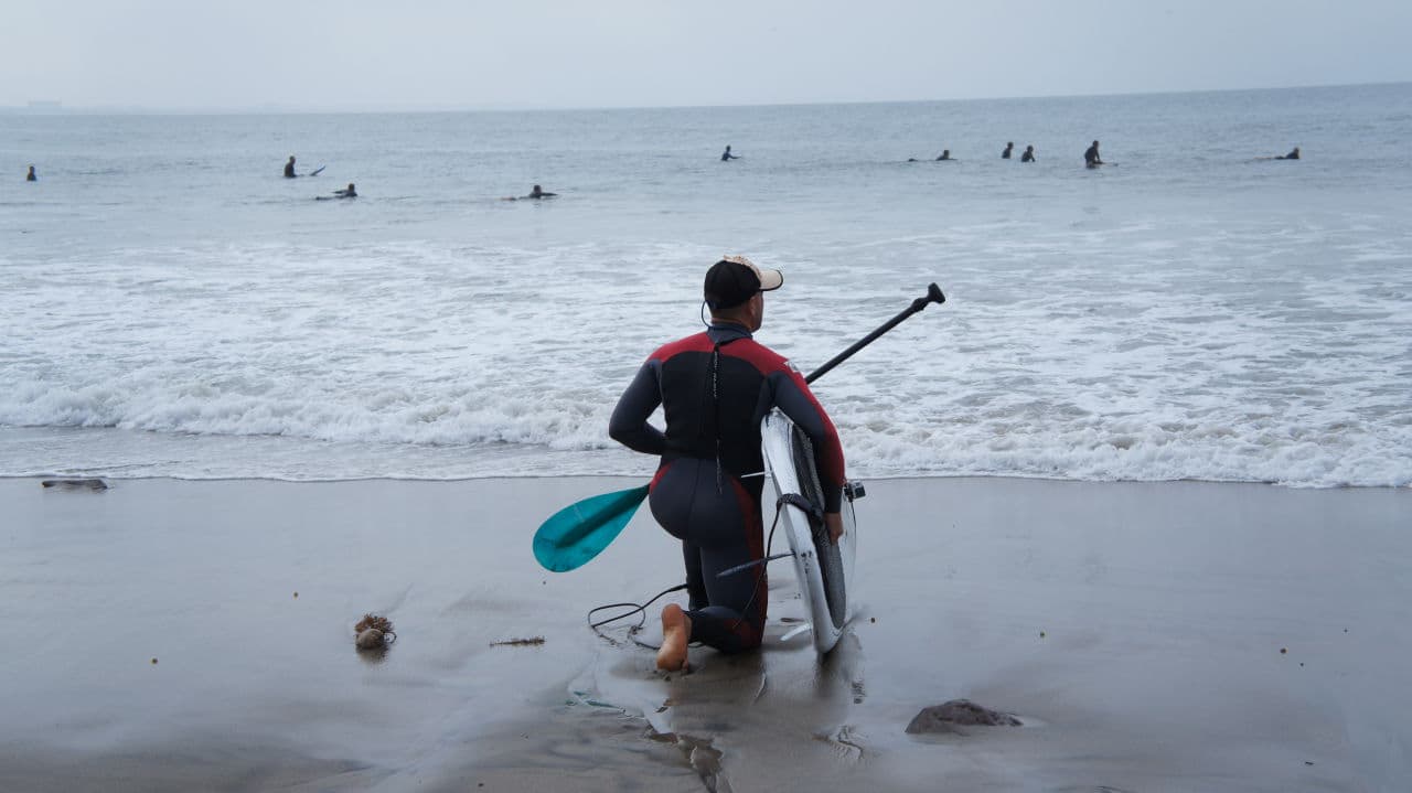 A paddle boarder surveys waves in Malibu before going into the water. (Saul Gonzalez/Only A Game)