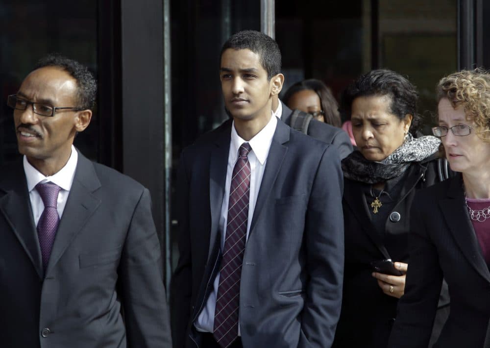 Robel Phillipos, center, departs federal court with his attorney in October 2014. On Friday he was sentenced to three years in prison for lying to law enforcement investigating the Boston Marathon bombing. (Stephan Savoia/AP)