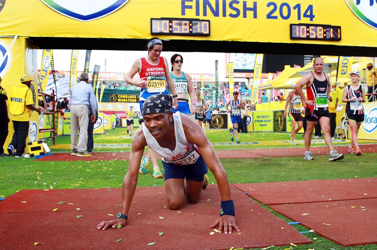 An exhausted runner collapses as he arrives at the finishing line at the end of the 89km Comrades Marathon in South Africa. As ultramarathons like this rise in popularity, some are worrying about a disease called overtraining syndrome. (Rajesh Jantilal/AFP/Getty Images)