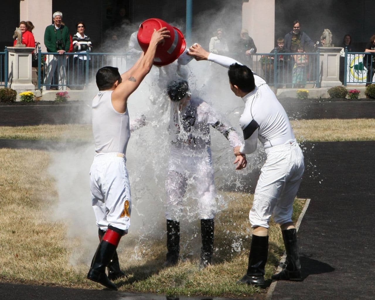 Two fellow jockeys dump a bucket of water on Richard after he notched his first U.S. win this spring. (Clementine Oliver)