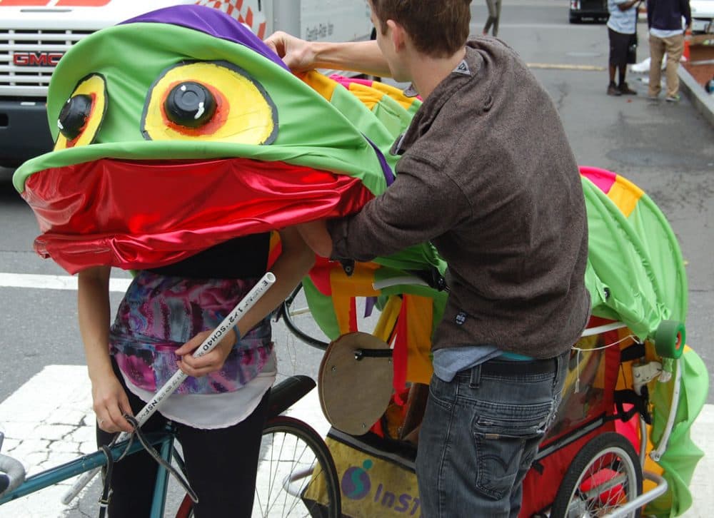 The Somerville-based “Everything Muffin Collective&quot; preps their caterpillar-bike before the race. (Greg Cook/WBUR)